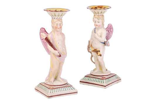 A Pair Of Early Staffordshire Ceramic Candlesticks Shaped As Putti, circa 1800